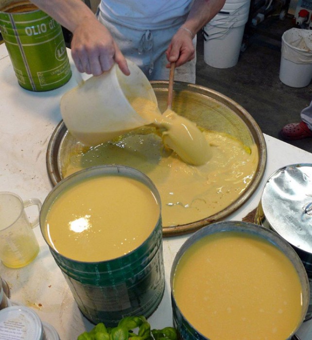 Preparing farinata, the traditional chickpea-flour pancake of Genoa, that cooks fast, in the pizza oven.