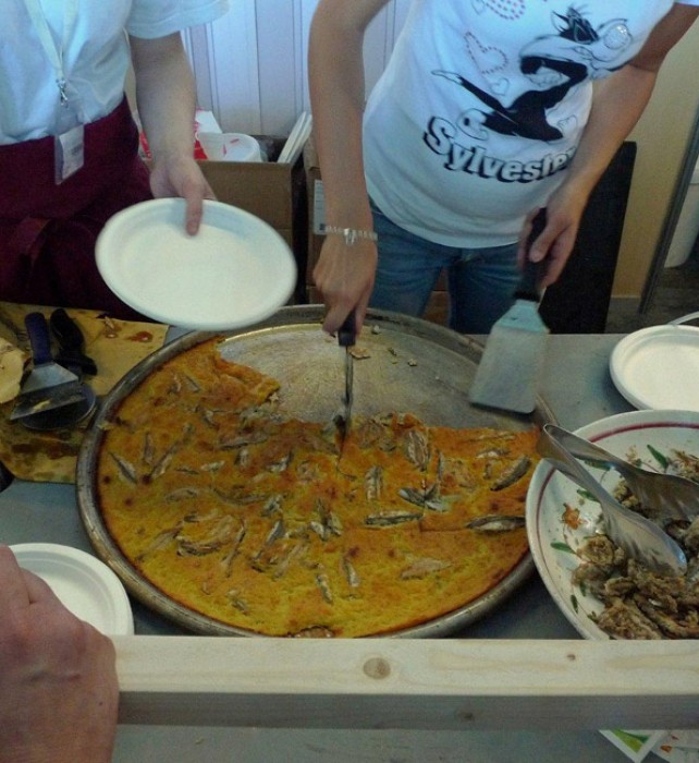 Anchovy Farinata is immediately cut and served to the participants of the Slow Fish who had been waiting patiently.